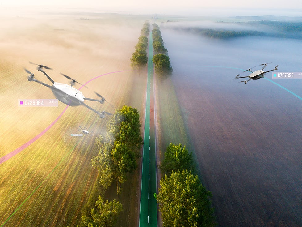 A digital rendering of an aerial shot of a long, tree-lined road cutting through fields, with multiple drones flying above a layer of fog, detecting flying conditions.