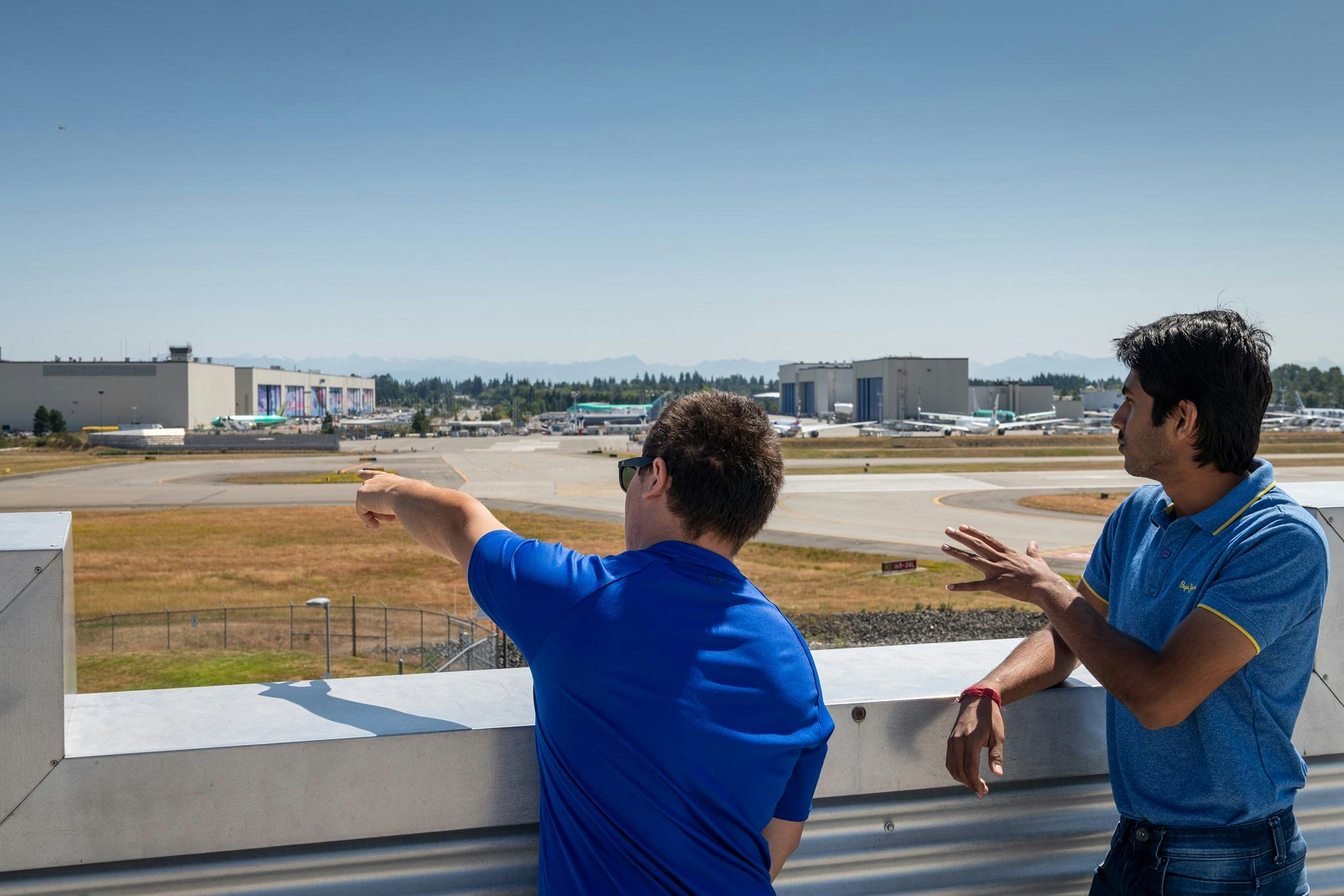Two adult guests look at Paine Field from the sky deck