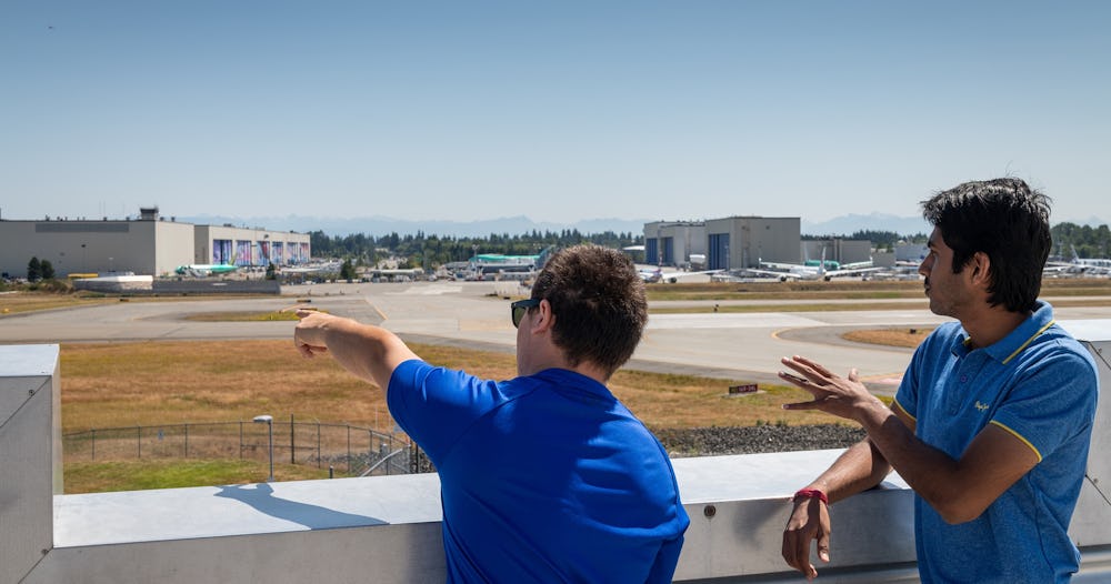 Two adult guests look at Paine Field from the sky deck