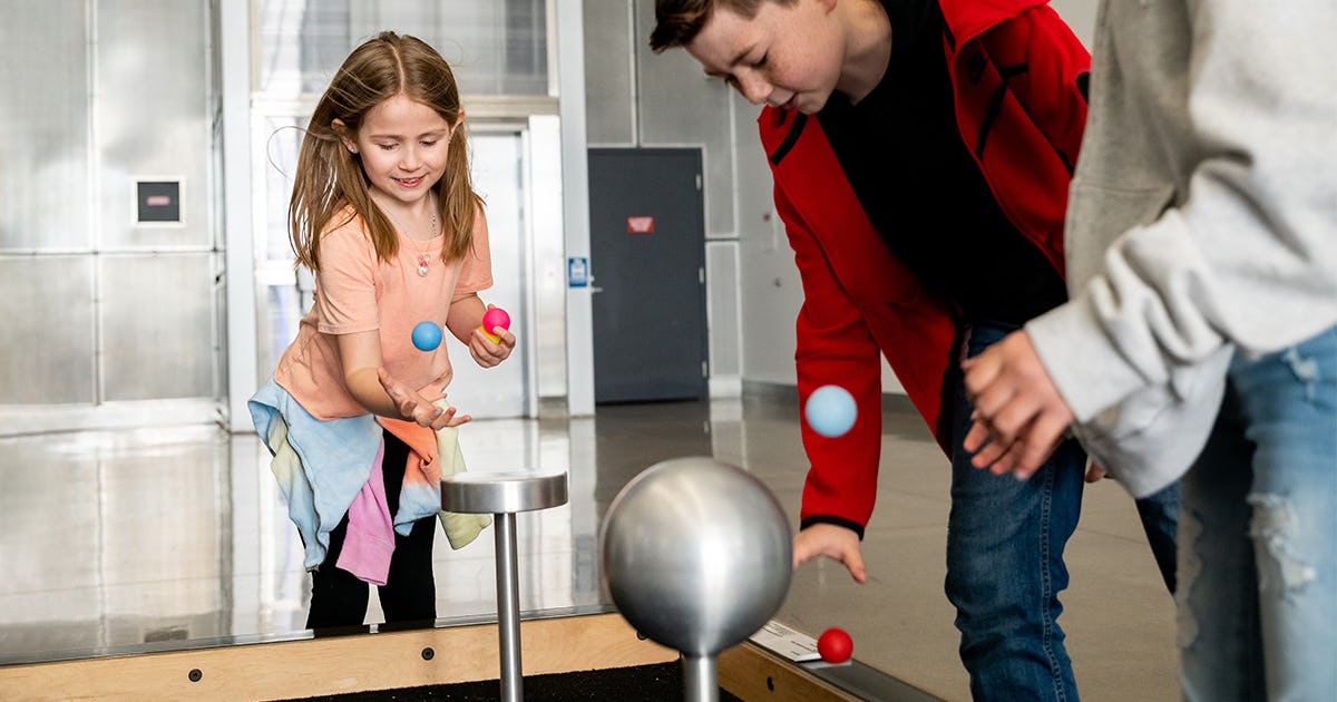 A group of kids playing at the Bernoulli table in our Kids' Zone.