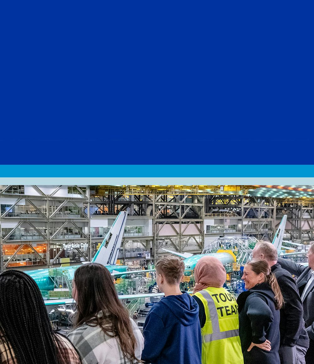 Group of tourist looking over the factory at a aircraft being built