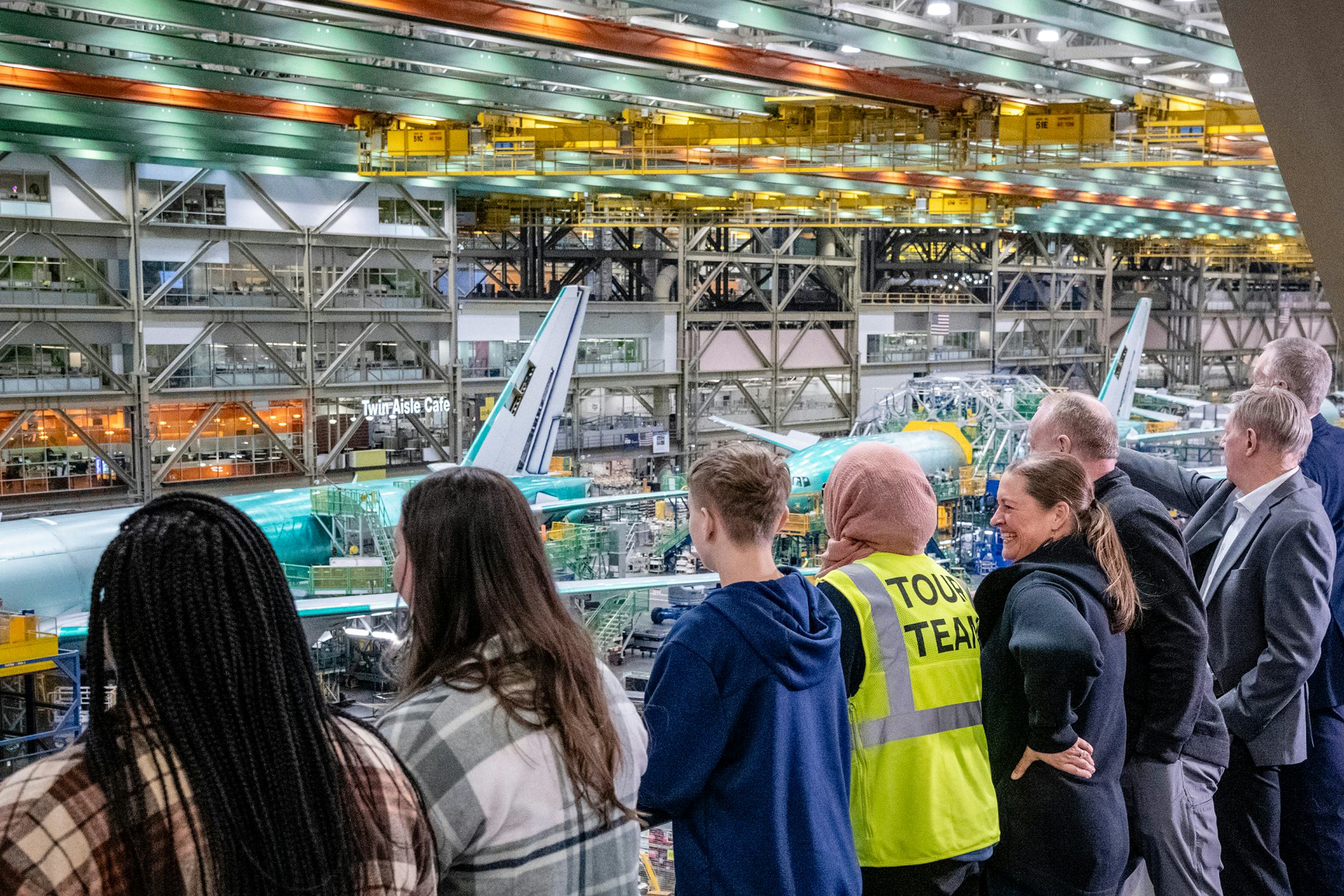 Group of tourist looking over the factory at a aircraft being built