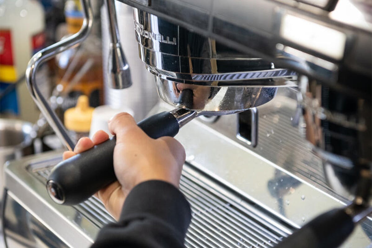 A barista making coffee with one of our Café's espresso machines.