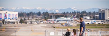 a dad with young kids stand on the sky deck and look at Paine Field