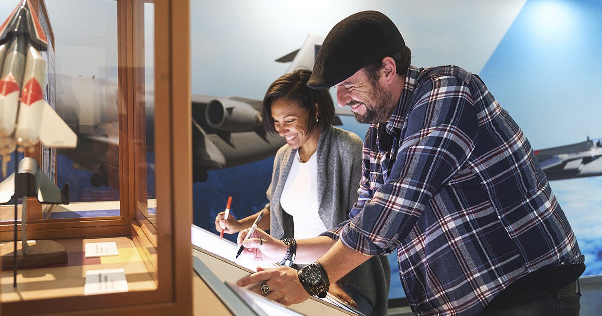 Guests exploring aviation exhibits inside the Boeing Future of Flight Gallery.